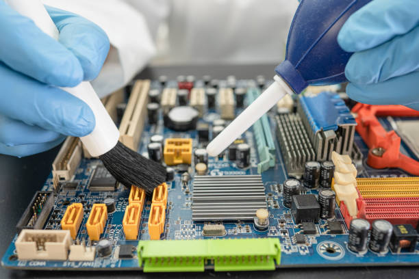 istock Technician use brush and air blower ball to clean dust in circuit board computer. Repair upgrade and maintenance technology. 1303100791