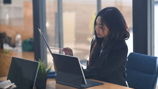 istock Attractive businesswoman working with computer tablet and analyzing document at modern office. 1303102551