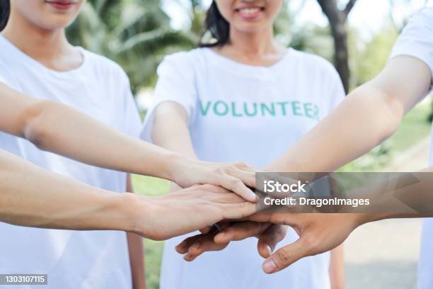 Volunteers Standing Hands Stock Photo - Download Image Now - Volunteer, Charity and Relief Work, Charitable Foundation