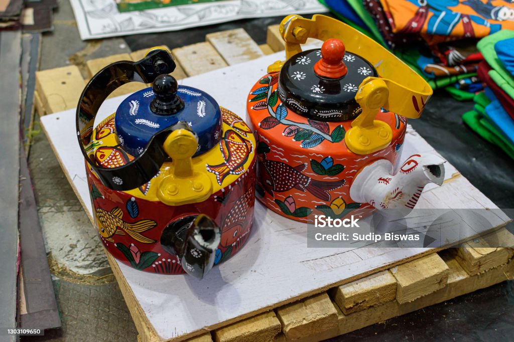Beautiful handmade decorative traditional Indian kettles are displayed in a shop for sale in blurred background. Indian handicraft. Multi Colored Stock Photo