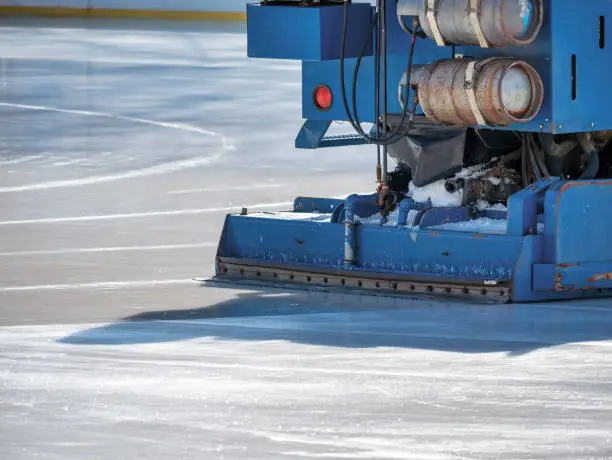 Ice resurfacer smoothing and polishing the surface of the ice rink