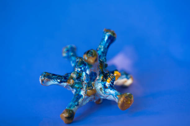 Imaginary Ceramic Models of Coronavirus mutation results in a new more infectious version of covid-19 virus. It is made of clay against blue cloudy background.