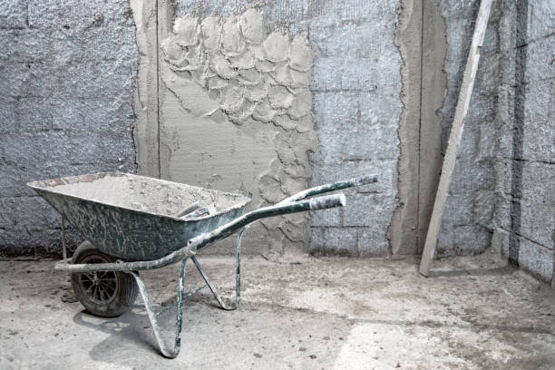 istock Wheelbarrow filled with mortar and cement on a construction site. 1303111887