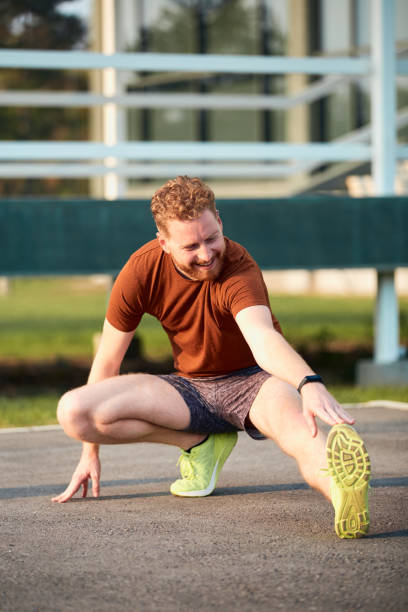 istock Young man stretching after jogging and exercising in urban park. 1303111902