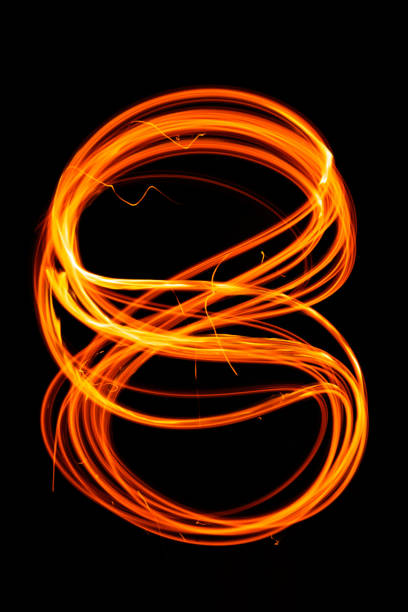 istock Drawing shapes with fire at night, infinity sign, bright colors on night background, fun with fire. 1303116664