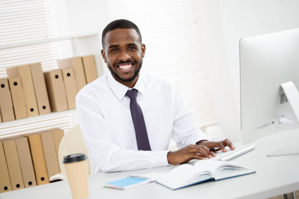 istock Happy african american businessman smiling at camera in office 1303119528