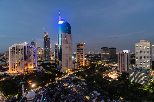 Stunning twilight over the Jakarta downtown distirct skyline, which contrast with low rise houses, in Indonesia capital city