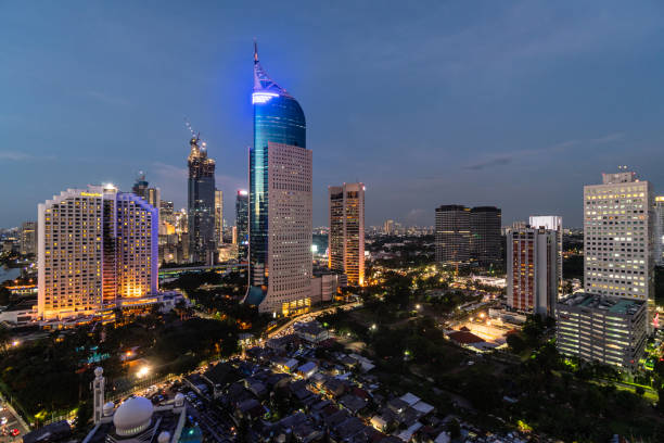 Stunning twilight over the Jakarta downtown distirct skyline, which contrast with low rise houses, in Indonesia capital city Stunning twilight over the Jakarta downtown distirct skyline, which contrast with low rise houses, in Indonesia capital city jakarta skyline stock pictures, royalty-free photos & images