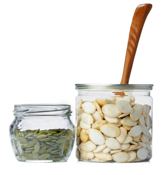 istock Glass jar with pumpkin seeds isolated on white 1303122019