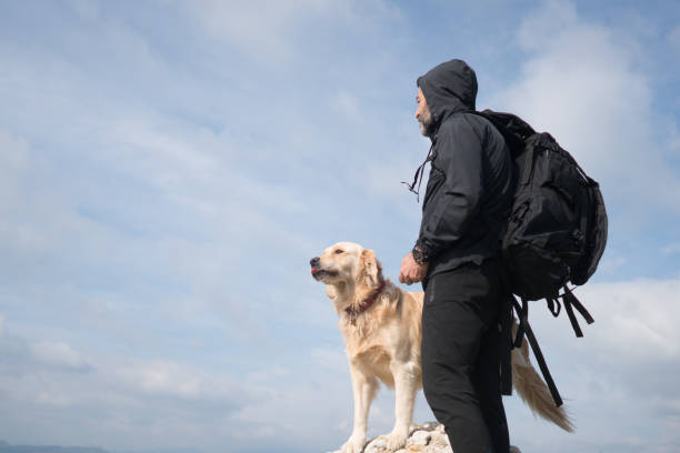istock Hikker man standing on mountain peak wit his dog. 1303122203