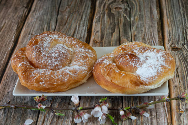 istock ensaimada, a typical Spanish pastry breakfast from Mallorca. Placed on a wood and with almond blossoms 1303122277