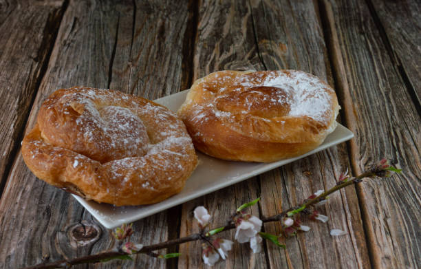 istock ensaimada, a typical Spanish pastry breakfast from Mallorca. Placed on a wood and with almond blossoms 1303122331