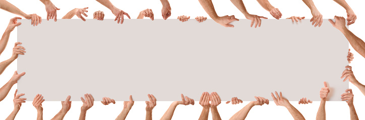 Many hands in different positions holding a poster with white isolated background. Panoramic composition