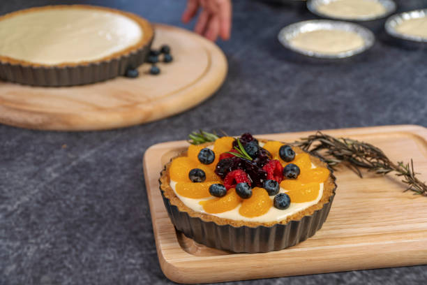istock Decorating blackberry pie using fresh fruits on table. Homemade bakery concept. 1303127305