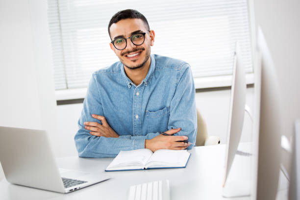 istock Happy arab businessman smiling while looking at camera in office 1303130862