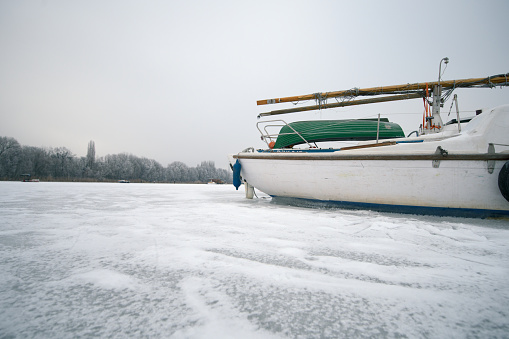 A white boat on the frozen Spree river