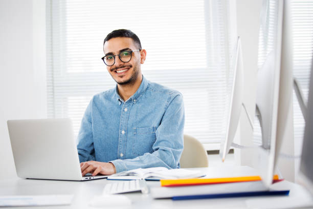 Happy arab businessman smiling while looking at camera in office stock photo