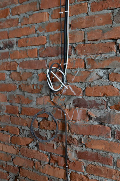 istock construction of a new house, electrical cables twisted into a knot and fixed to a brick wall close-up, without people 1303133320
