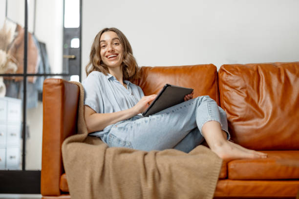 istock Woman working with digital tablet from home on sofa 1303136954