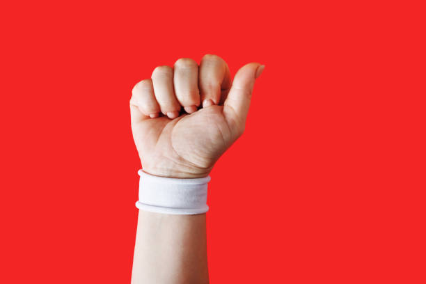 Clenched fist female hand on red backgroung.