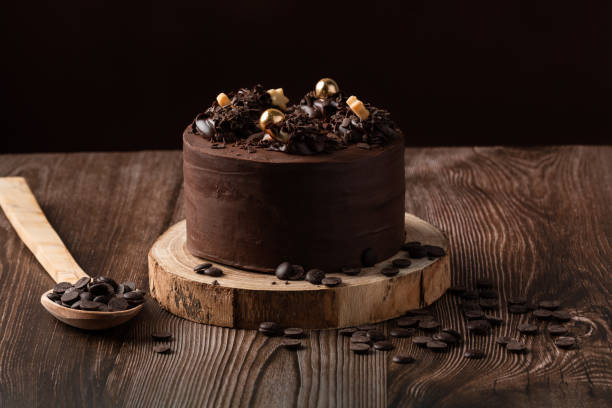 istock front view of chocolate cake, with chocolate chips, spoon and wooden table. 1303140017