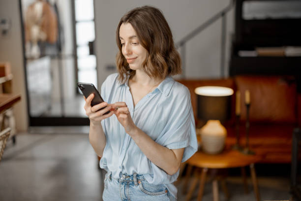 istock Woman using Smartphone in living room 1303140836