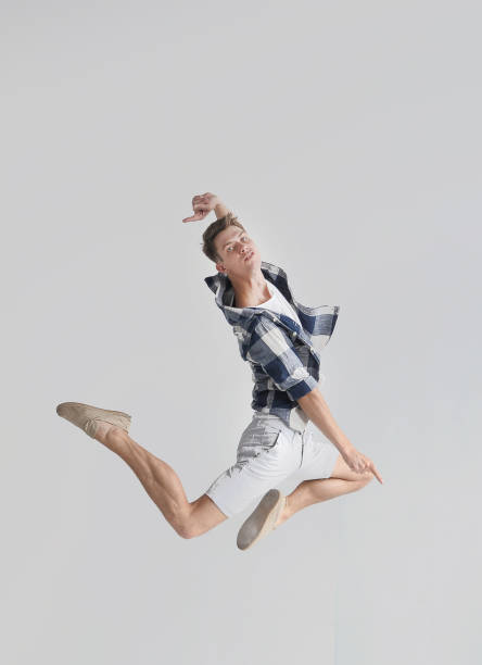 istock Stylish dancer man jumping in light syudio 1303141002