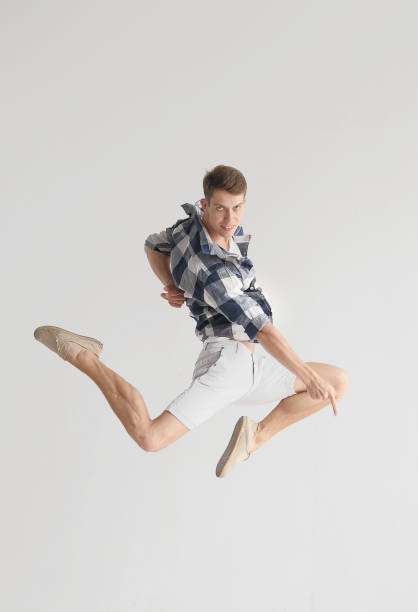 istock Stylish dancer man jumping in light syudio 1303141023