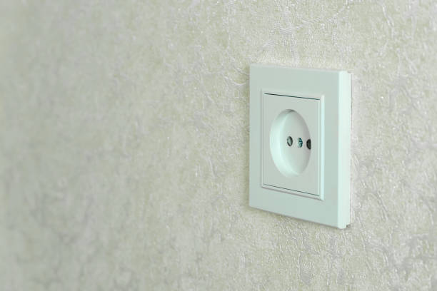 istock White electrical outlet on a white wall close-up with copy space, photo at an angle 1303141645