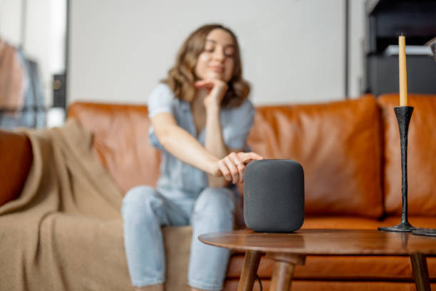 istock Woman touching black audio assistant column on the coffee table 1303141854