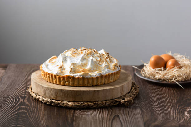 istock Lemon pie on top of log and wooden table. front view 1303144671