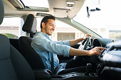 Attractive male driver using the GPS navigation map on the car