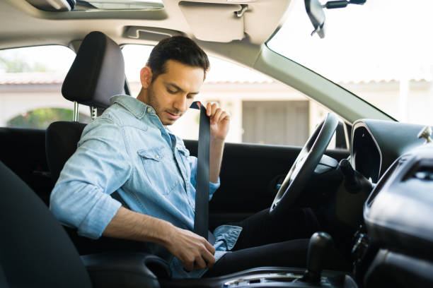 istock Male driver behind the wheel putting on his seatbelt 1303145857
