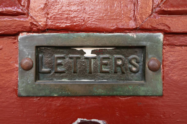 istock Old mail slot in a red door 1303147101
