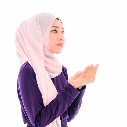 Beautiful young muslim women wear hijab make a wish and praying from allah with isolated on white background. Religion, belief and faith islam.