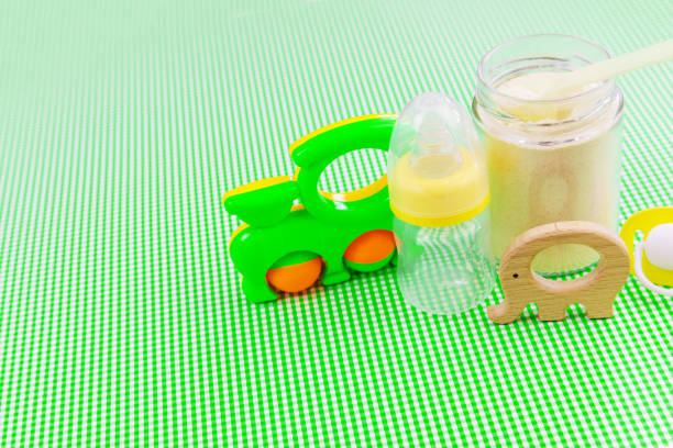istock Baby accessories and food on a green background. Selective focus. 1303149177