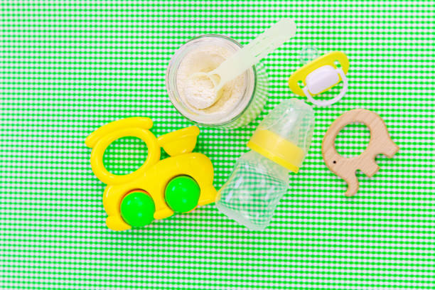istock Baby accessories and food on a green background. Selective focus. 1303149189