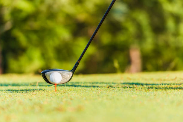 istock Closeup of golf ball on tee off and driver 1303149720