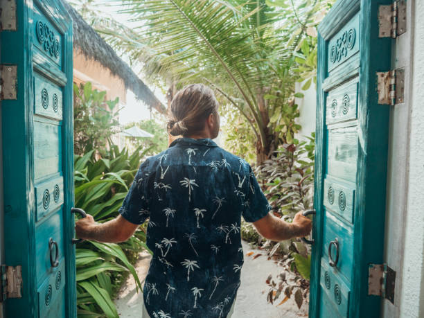 istock Man opening doors of luxury beach villa 1303151881