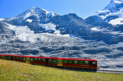 Lauterbrunnen, Switzerland - August 26, 2019. Beautiful scenery with cogwheel red train of the famous Jungfrau Railway from Jungfraujoch ( Top of Europe) to Kleine Scheidegg, Bernese Oberland, Switzerland