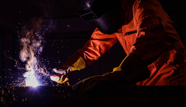 istock Man worker wearing fire protective mask and fire protection gloves with personal protection equipment standing steel box welding 1303153018