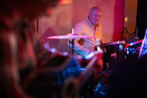 Drummer plays the drums during gig in nightclub