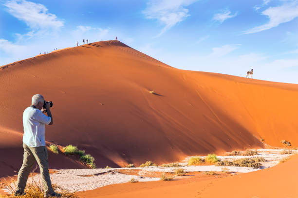 istock Tourist photographs orange dunes 1303157894