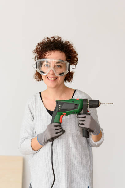 istock Young woman holding a drill, ready to make home improvements 1303158225