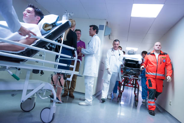 istock Transporting one patient on stretcher while doctor talking to people 1303165302