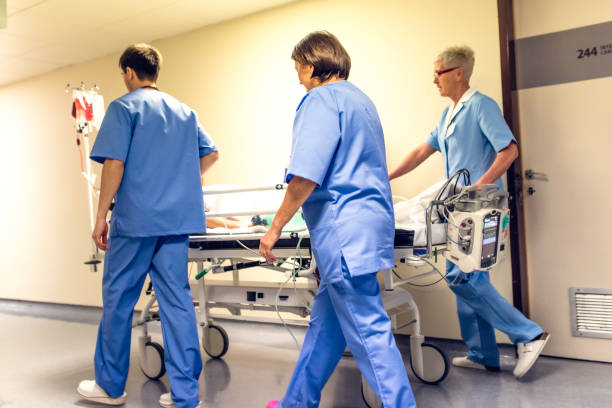 istock Nurses transporting patient down hospital corridor 1303165317