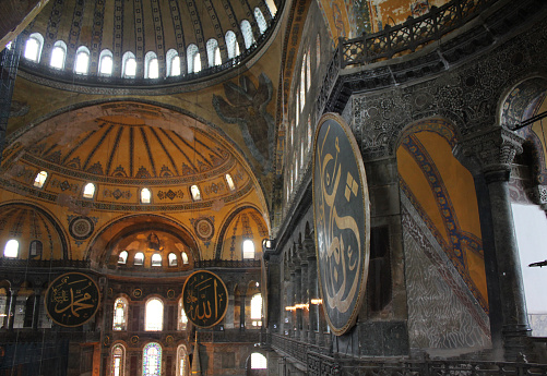 Istanbul, Turkey-May 11, 2014: Architectural Sections from the Interior of the Hagia Sophia Mosque, Columns, mosaics on the walls, dome decorations and large old chandeliers. There are Christian frescoes and Arabic Scripts on the walls.