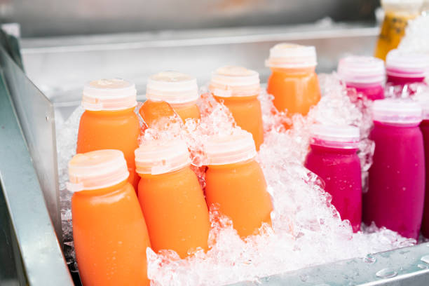 istock Mixed orange juice cold cups on ice in the flea market 1303168178