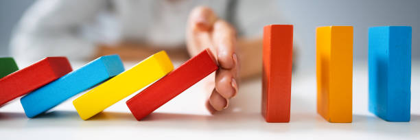 istock Businessperson Hand Stopping Colorful Blocks From Falling 1303171923