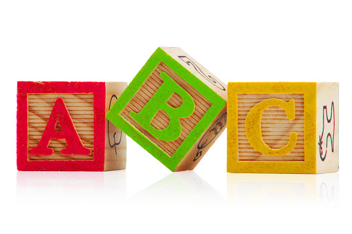 Three children's wood blocks on white background with letters A, B and C